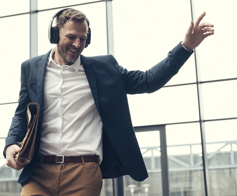 Happy businessman listening to music with headphones Sound Therapy